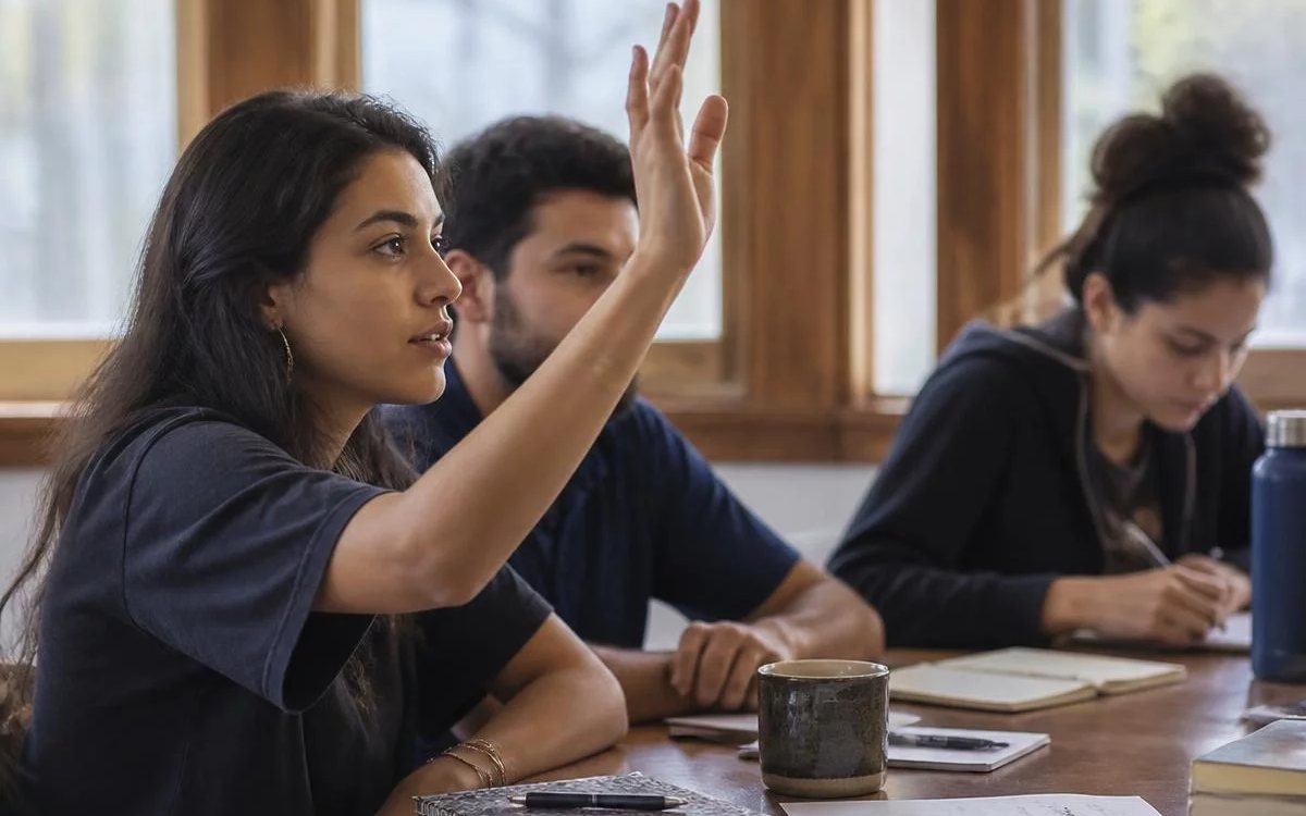 Grupo pequeno reunido em volta da mesa, ouvindo a fala de quem tem a palavra